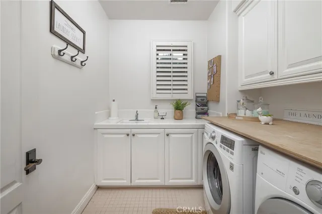 a utility room with cabinets washer and dryer