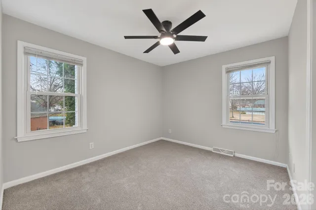 an empty room with a window and a ceiling fan