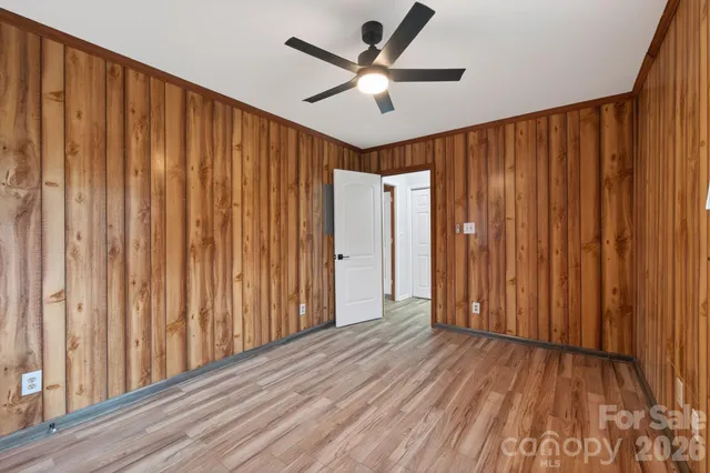 a view of wooden floor and a ceiling fan in a room
