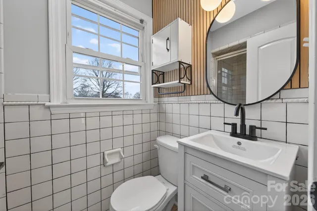 a bathroom with a sink mirror and toilet