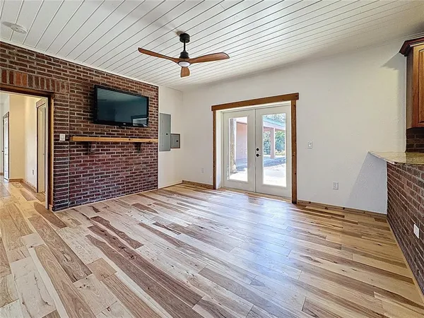 a dining room with furniture a chandelier and wooden floor
