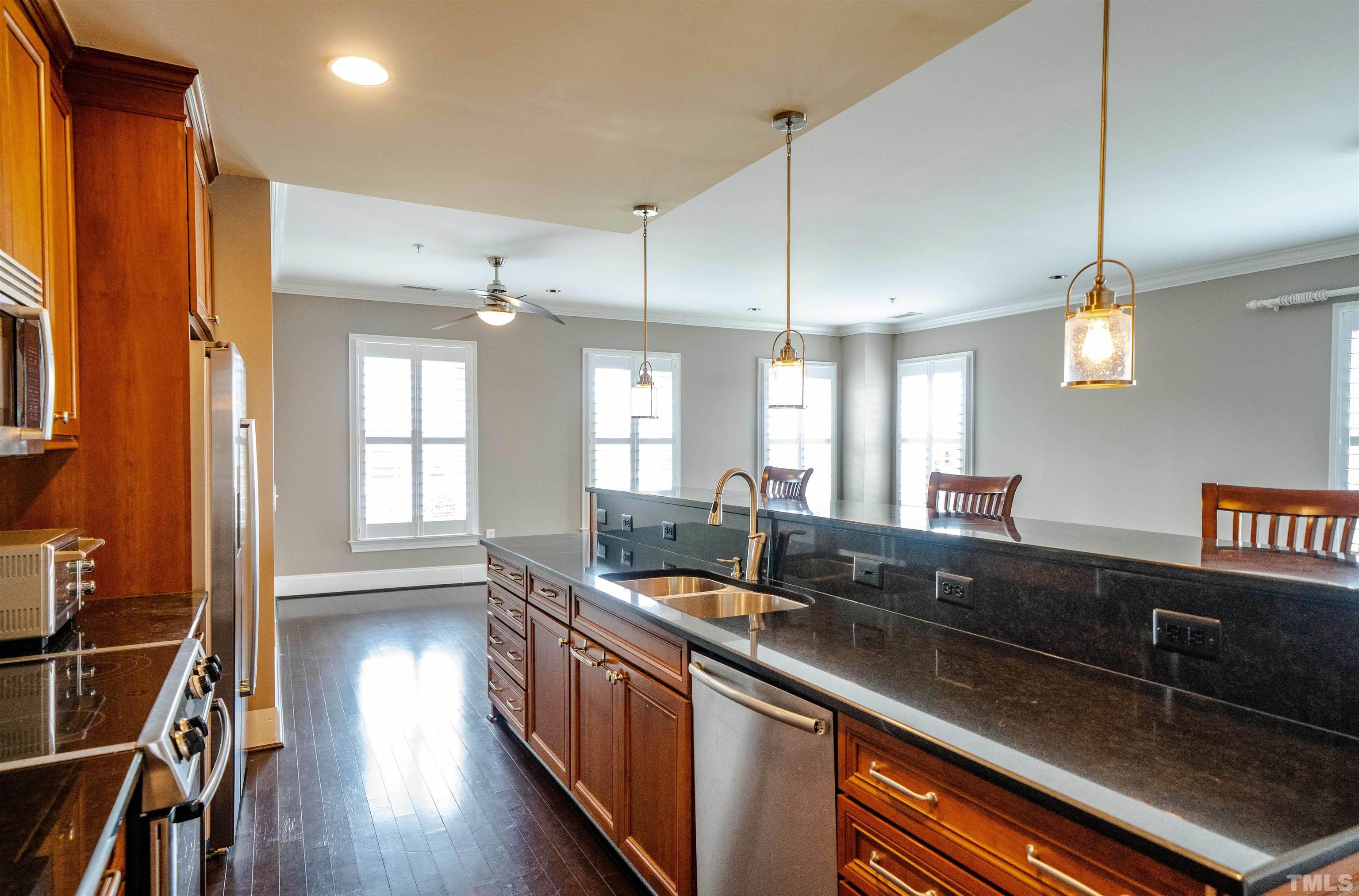 710 Independence Place, Unit 407 Raleigh, NC 27603 - Photo 3 of 10 a large kitchen with a lot of counter space and a wooden floor