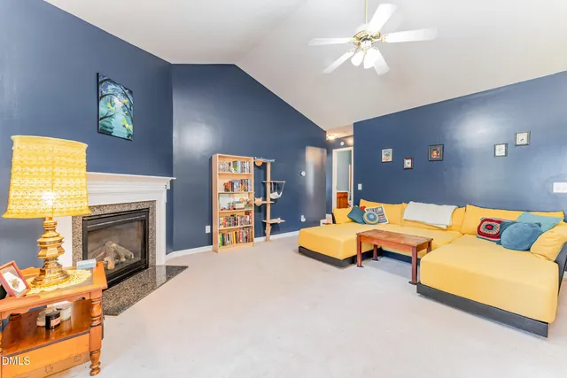 a living room with furniture a fireplace and a large window