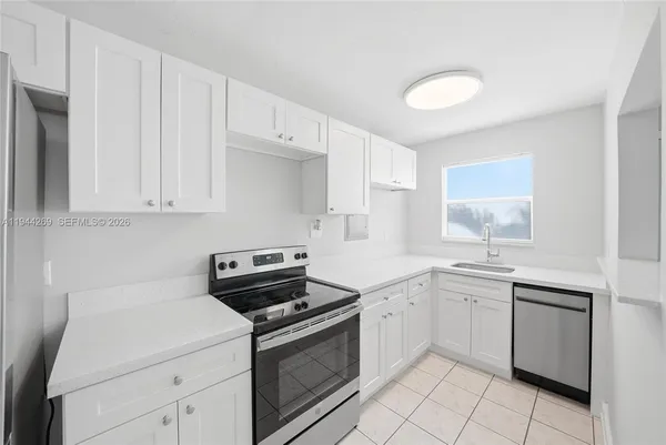 a kitchen with a sink stove and cabinets