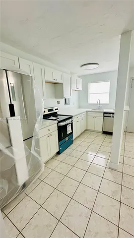 a kitchen with a sink a stove and cabinets