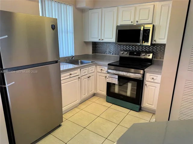 a kitchen with stainless steel appliances a refrigerator sink and microwave