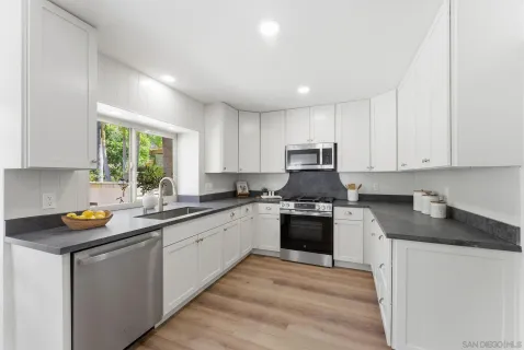 a kitchen with stainless steel appliances a refrigerator a stove microwave and furniture
