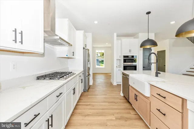 a large kitchen with stainless steel appliances granite countertop a stove a sink and a refrigerator