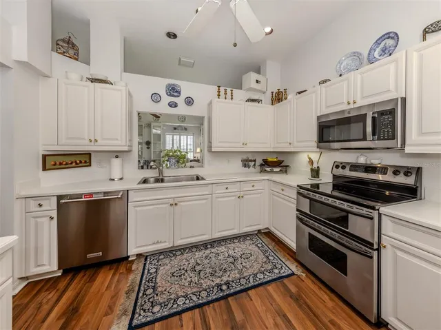 a kitchen with a sink stove and white cabinets