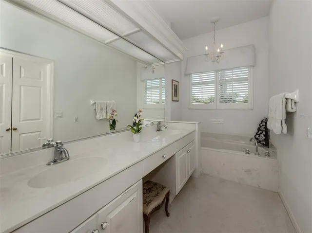 a bathroom with a double vanity sink a mirror and a bathtub