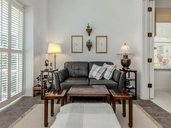 a living room with furniture a lamp and a window