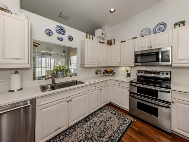 a kitchen with white cabinets and sink