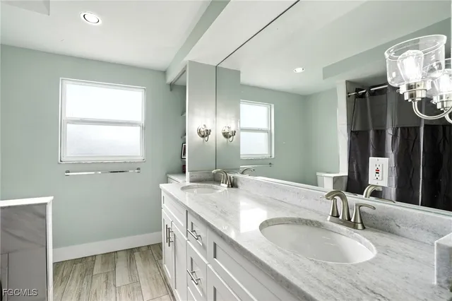a bathroom with double vanity and a mirror