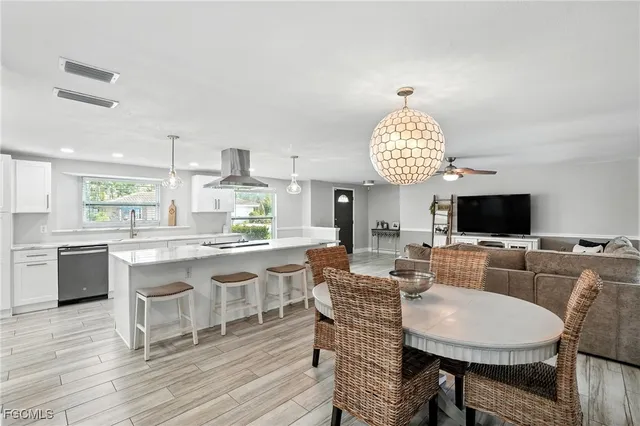 a living room with kitchen island furniture a flat screen tv and kitchen view
