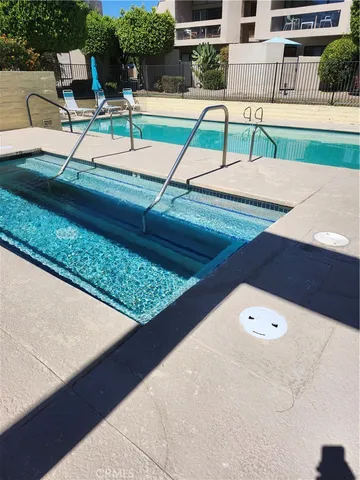 a view of a yard with plants and palm trees