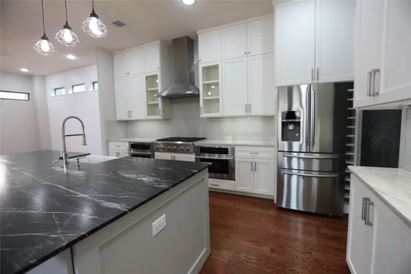 a kitchen with stainless steel appliances granite countertop a sink a stove and a refrigerator