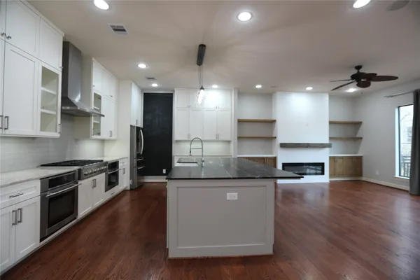 a large kitchen with stainless steel appliances granite countertop a stove a sink and a refrigerator