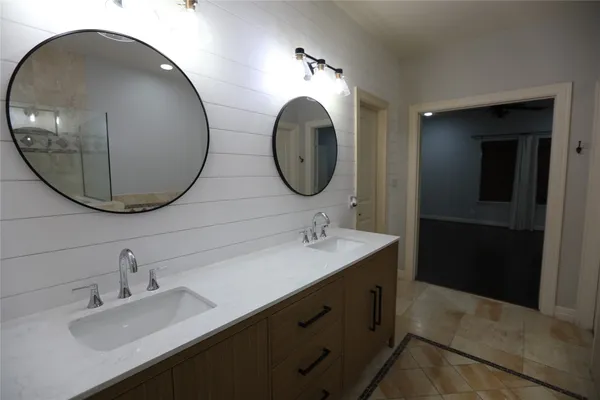 a bathroom with a double vanity sink and a mirror