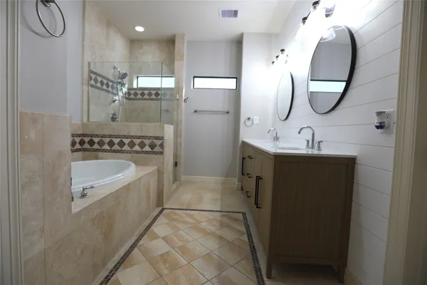 a spacious bathroom with a sink a mirror a shower and a mirror