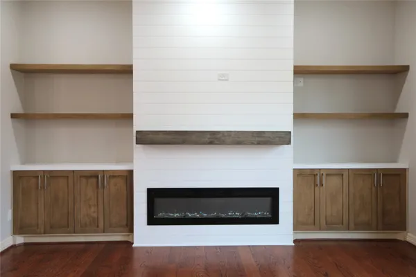 a living room with a fireplace and wooden floor