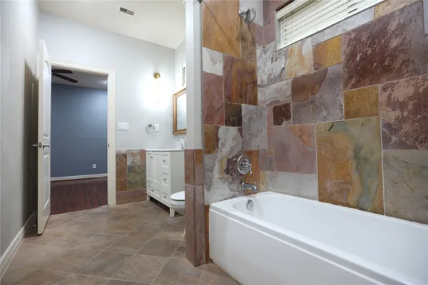 a bathroom with a bathtub a toilet and a shower