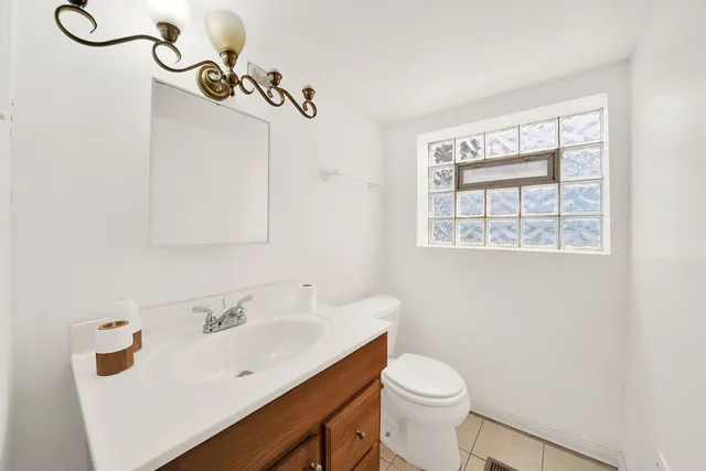 a bathroom with a sink vanity mirror and toilet