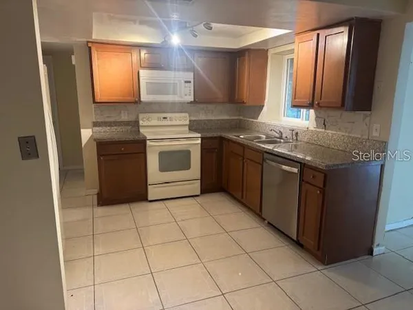 a kitchen with stainless steel appliances granite countertop a stove a sink and a microwave