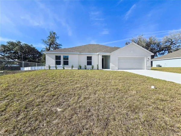 a large white house with a big yard and large trees