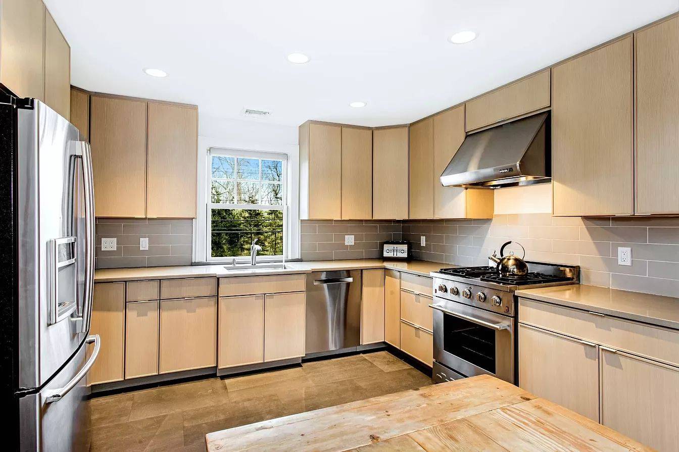 3752 Noyack Road Sag Harbor, NY 11963 - Photo 6 of 17 a kitchen with a stove a sink and a refrigerator