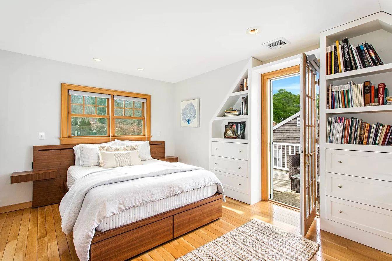 3752 Noyack Road Sag Harbor, NY 11963 - Photo 8 of 17 a bedroom with a bed a dresser and a book shelf