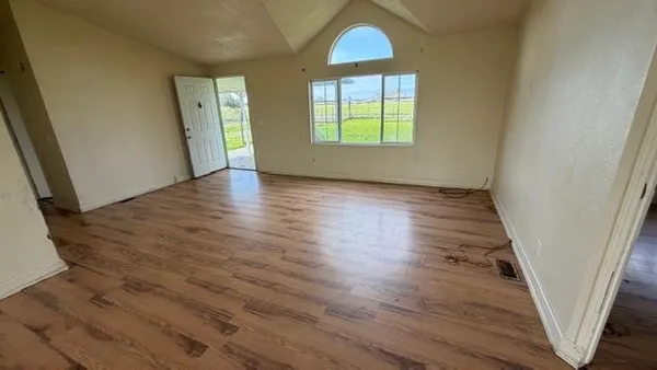 a kitchen with granite countertop a stove a sink and wooden floor