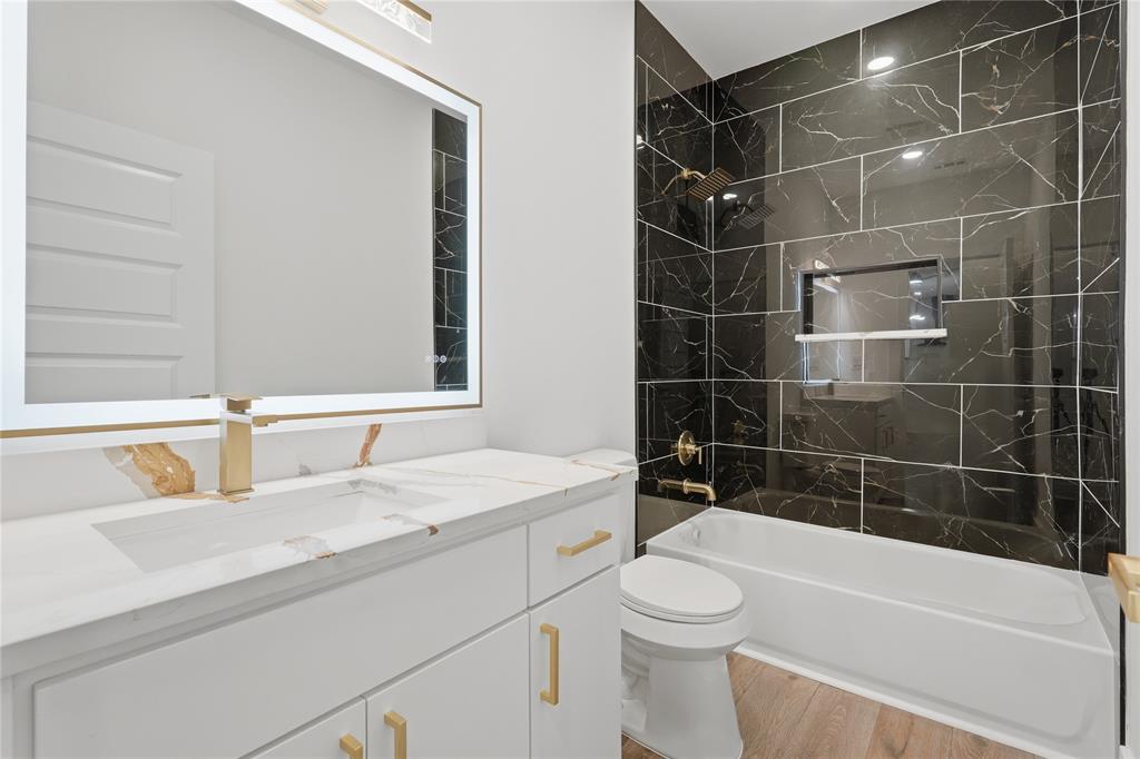 130 Cedar Elm Road Trinidad, TX 75163 - Photo 19 of 27 Modern bathroom featuring a white vanity with gold-tone hardware, a rectangular undermount sink, and a gold-tone faucet