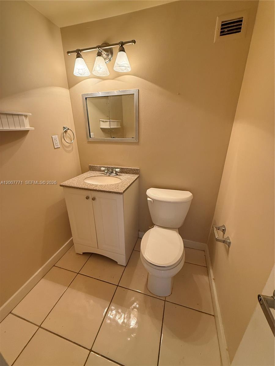 5313 Collins Avenue, Unit 906 Miami Beach, FL 33140 - Photo 2 of 3 a bathroom with a toilet a sink and mirror