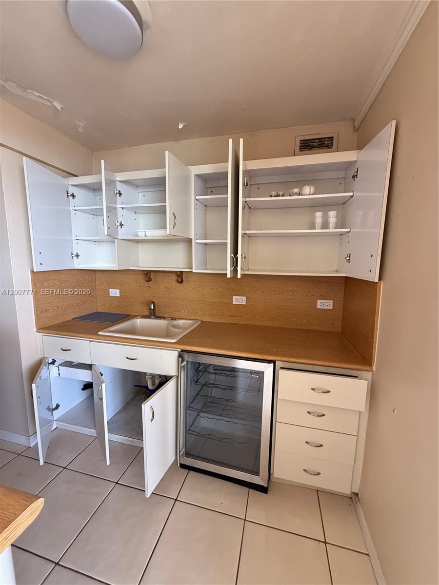 5313 Collins Avenue, Unit 906 Miami Beach, FL 33140 - Photo 3 of 3 a kitchen with a sink a stove and cabinets