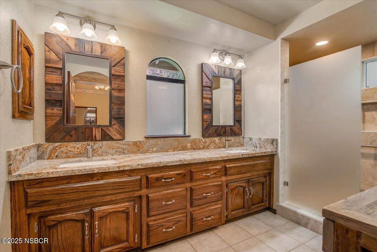 628 St Andrews Way Lompoc, CA 93436 - Photo 24 of 36 a bathroom with a granite countertop double vanity sink and a mirror
