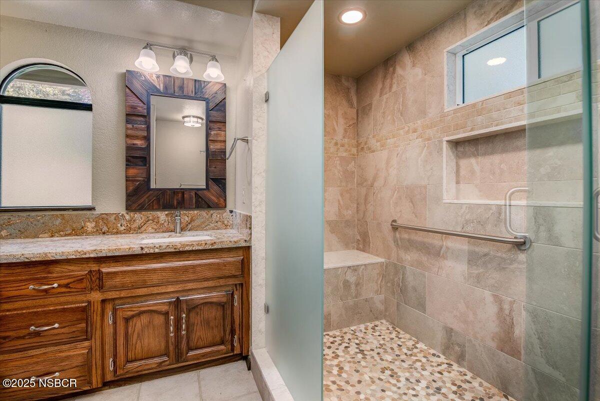 628 St Andrews Way Lompoc, CA 93436 - Photo 25 of 36 a bathroom with a granite countertop sink a mirror and a shower