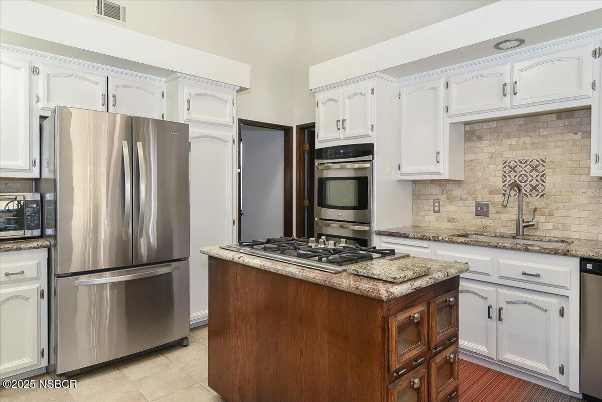 628 St Andrews Way Lompoc, CA 93436 - Photo 6 of 36 a kitchen with granite countertop a refrigerator stove and sink with granite countertops