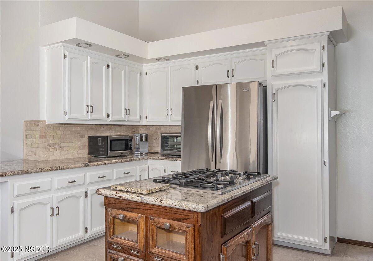 628 St Andrews Way Lompoc, CA 93436 - Photo 7 of 36 a kitchen with stainless steel appliances granite countertop a stove and a refrigerator