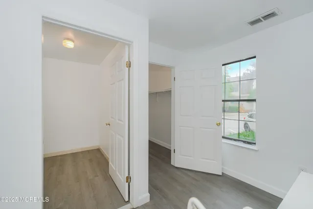 an empty room with windows and closet