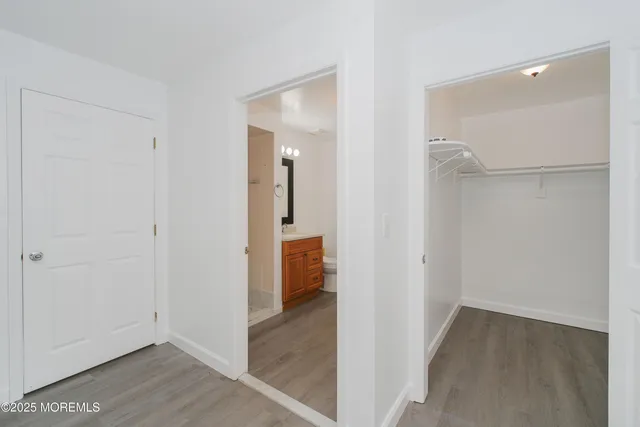 a view of a hallway with wooden floor and closet area