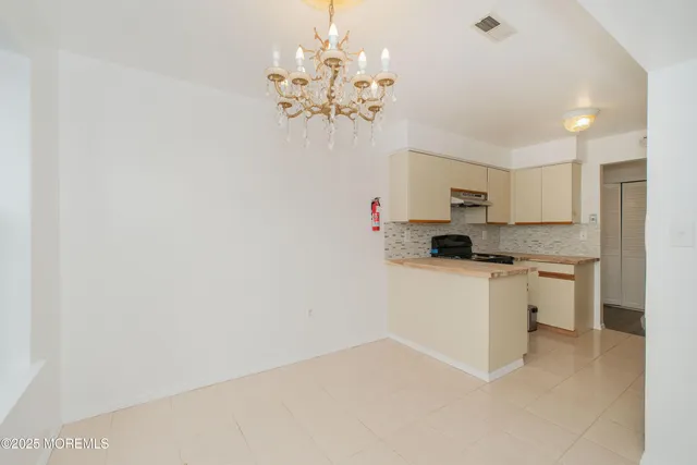 a kitchen with a refrigerator and a stove top oven