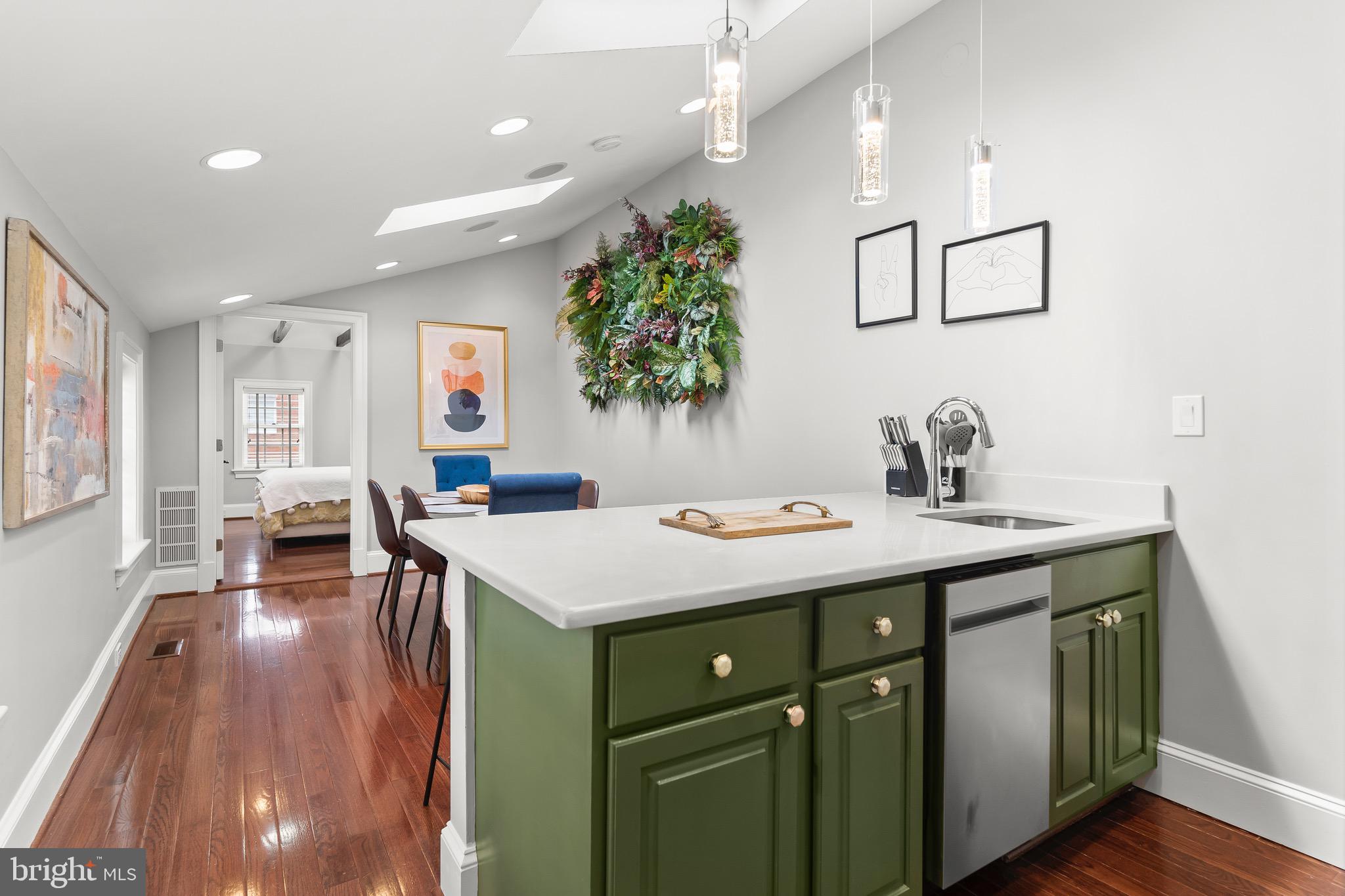 123 South Fayette Street Alexandria, VA 22314 - Photo 23 of 41 a view of kitchen island with stainless steel appliances granite countertop a sink dishwasher and a dining table with wooden floor