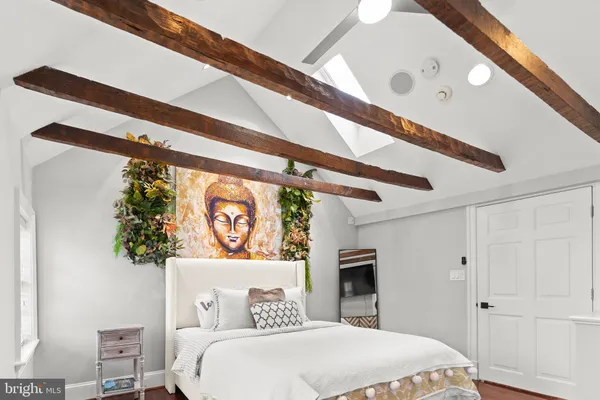a bedroom with a bed and a painting on the wall