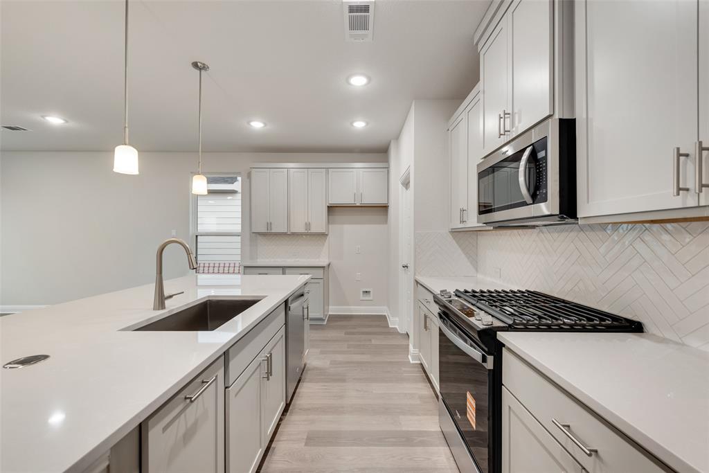 1013 Canoe Way Crowley, TX 76036 - Photo 8 of 26 a kitchen with stainless steel appliances granite countertop a sink a stove and a wooden floors