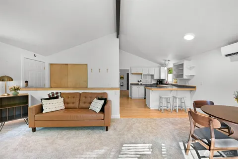 a living room with furniture and kitchen view