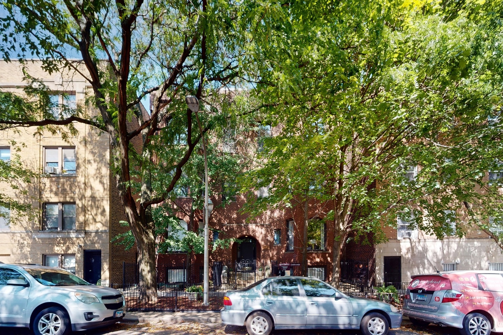 a front view of a building with trees