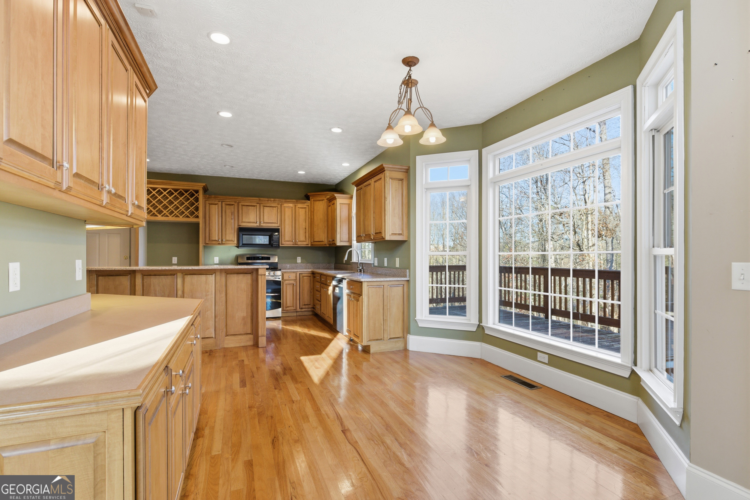 180 Springbrook Drive Cornelia, GA 30531 - Photo 10 of 50 a view of a kitchen with kitchen island granite countertop a large window a sink and a counter top space