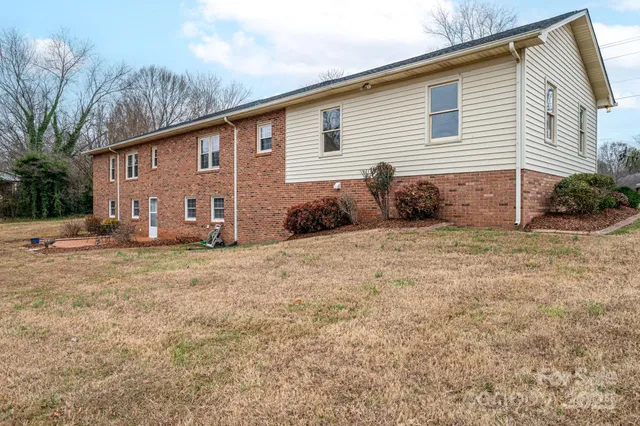 a view of a house with a yard and lawn chairs
