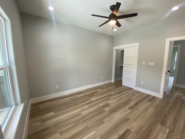 116 Field Street Luling, TX 78648 - Photo 22 of 33 Well-lit sleeping quarters with a ceiling fan and elegant wood flooring, ready for personalization.