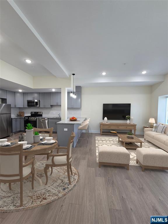 512 Kearny Avenue, Unit 202 Kearny, NJ 07032 - Photo 5 of 13 a living room with furniture a flat screen tv and kitchen view